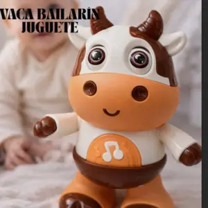 Vaca robot bailarina interactiva en colores blanco, marrón y naranja con ojos grandes y símbolo musical en el pecho, frente a un bebé.
